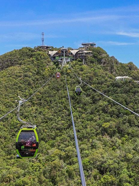 SkyCab Cable Car ascending over lush hills towards Langkawi Sky Bridge, Malaysia.