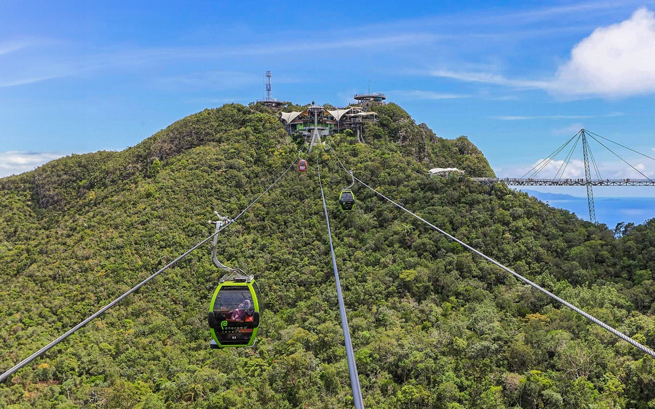 SkyCab Cable Car ascending over lush hills towards Langkawi Sky Bridge, Malaysia.