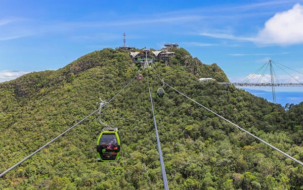SkyCab Cable Car ascending over lush hills towards Langkawi Sky Bridge, Malaysia.