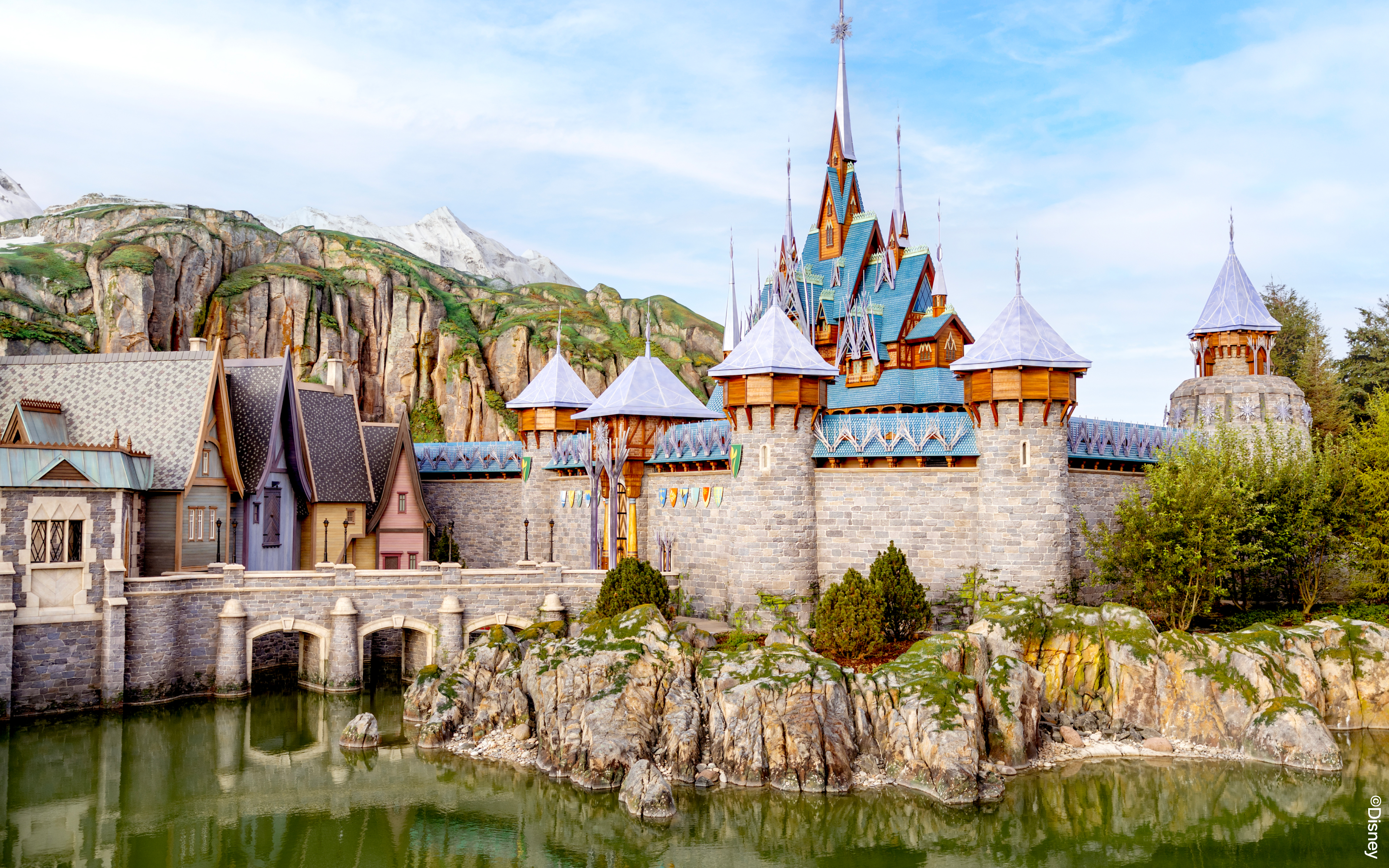 Arendelle castle and village at Disneyland World of Frozen, surrounded by rocky landscape.