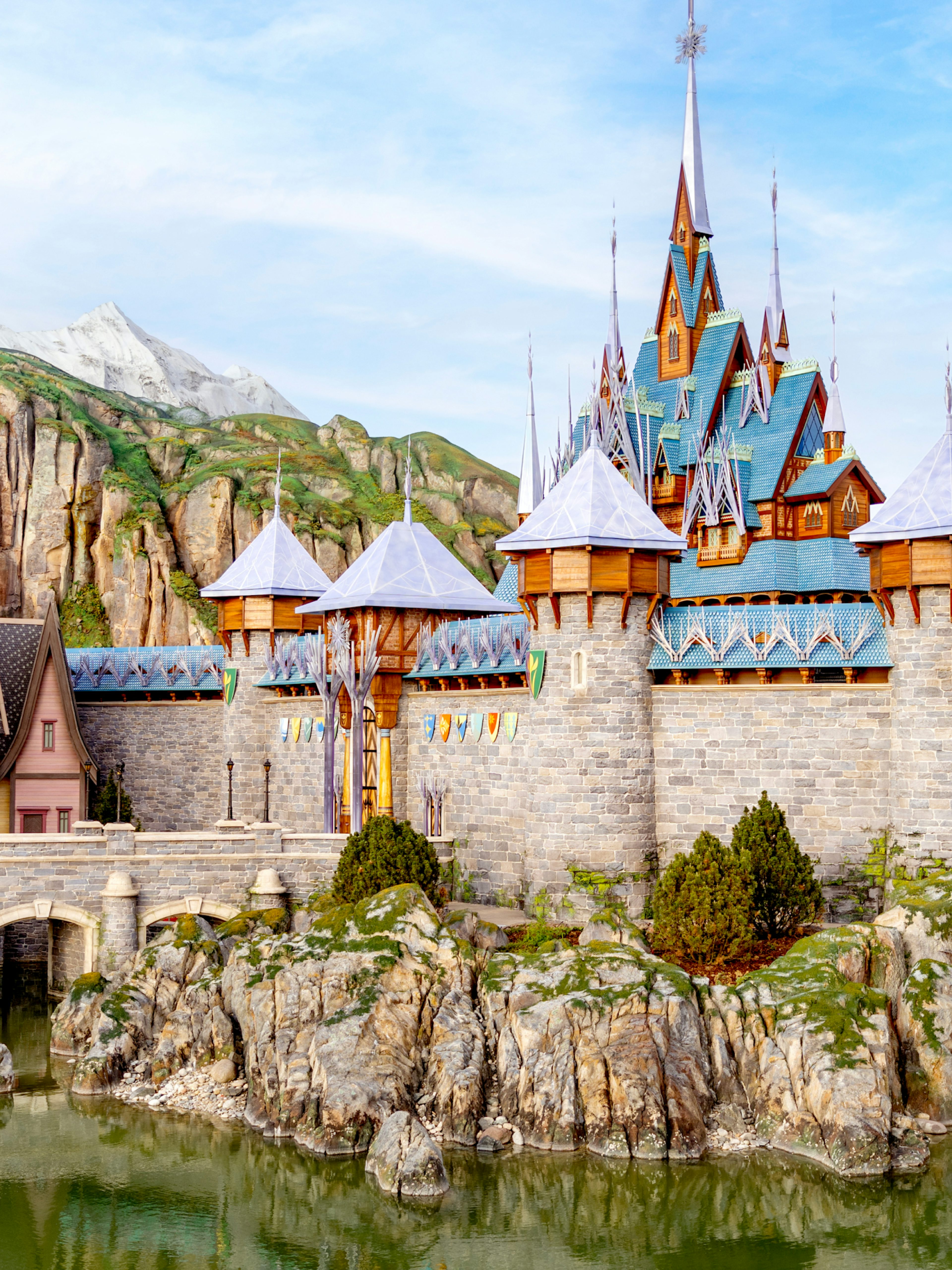 Arendelle castle and village at Disneyland World of Frozen, surrounded by rocky landscape.