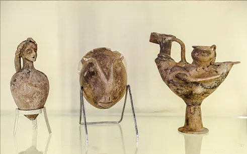 Ancient pottery artifacts displayed in Amman museum during city sightseeing tour.