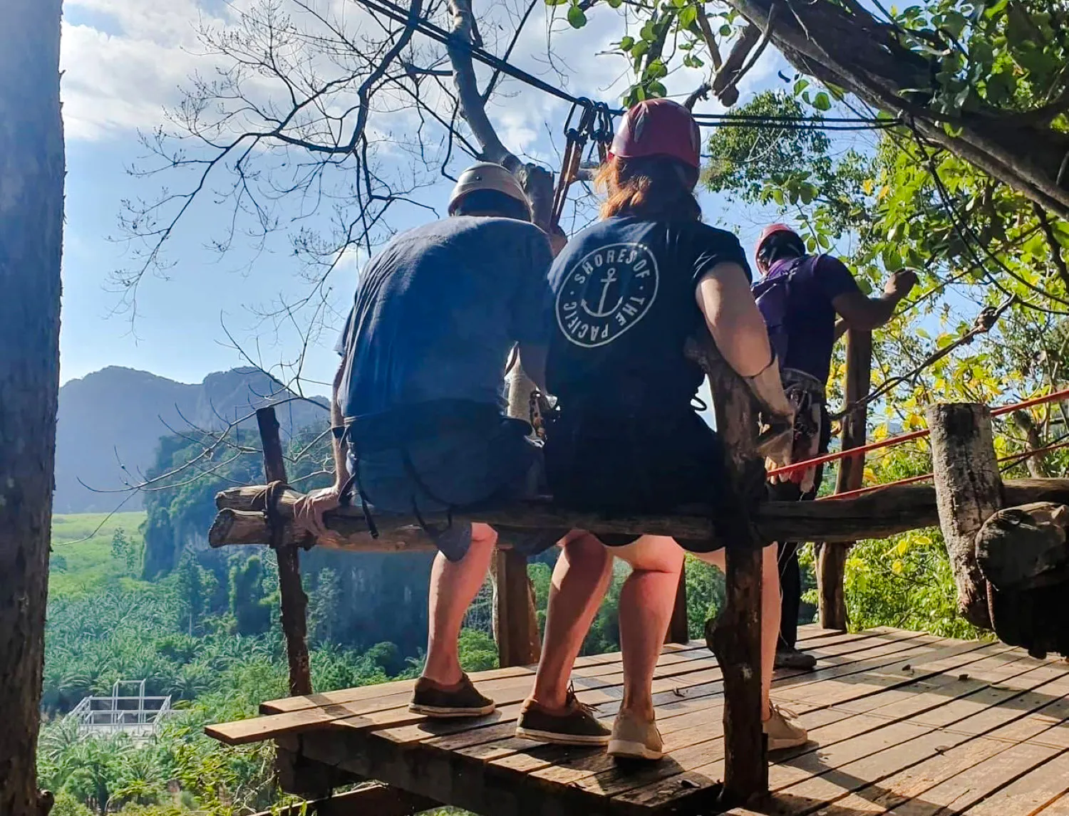Participants preparing for zipline adventure in Krabi with scenic mountain view.