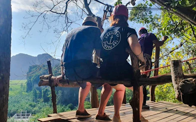 Participants preparing for zipline adventure in Krabi with scenic mountain view.