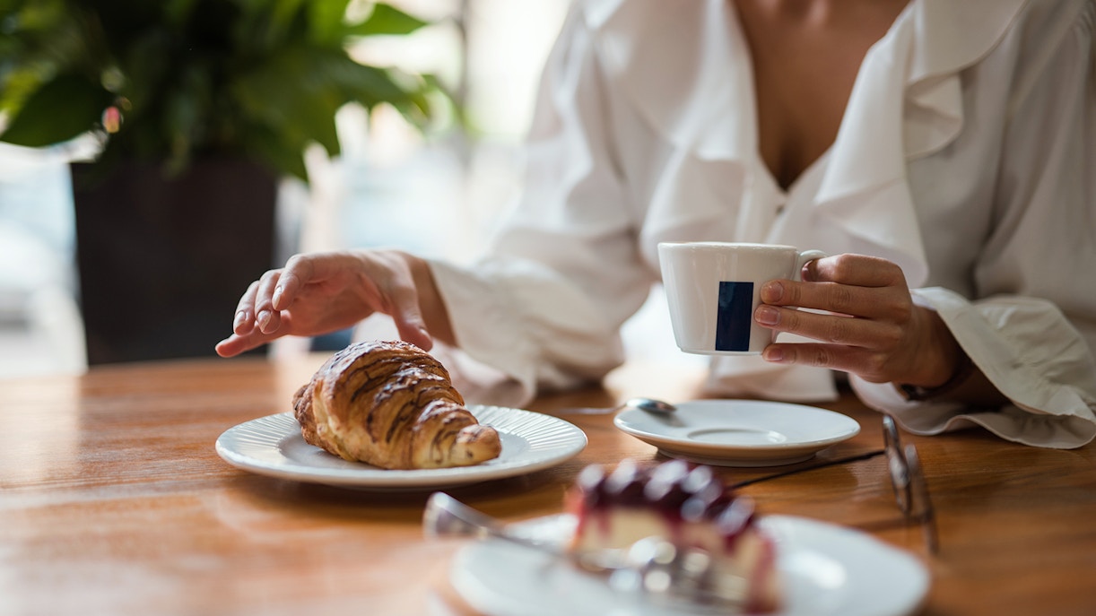 Croissant and coffee on a table at a French cafe in Paris.