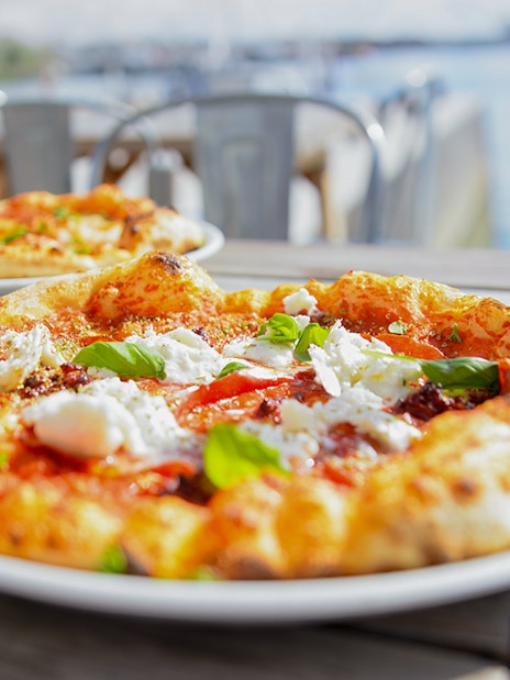 Pizza on table with view of Bay of Naples during Pompeii tour lunch.