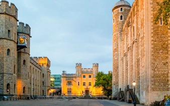 Tower of London compounds illuminated at night, showcasing historic architecture.