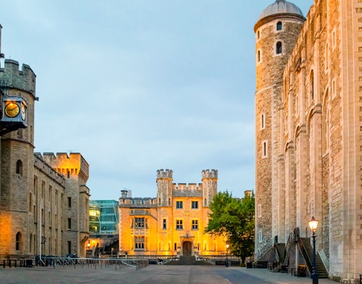 Tower of London compounds illuminated at night, showcasing historic architecture.