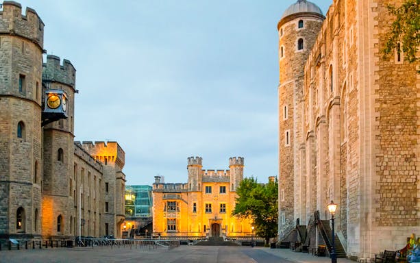 Tower of London compounds illuminated at night, showcasing historic architecture.