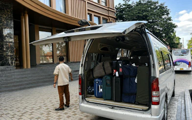 Van loaded with luggage outside Chiang Mai hotel for private transfer.