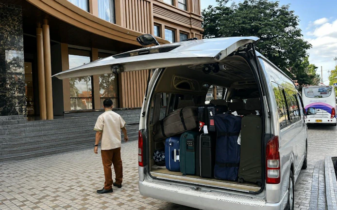 Van loaded with luggage outside Chiang Mai hotel for private transfer.
