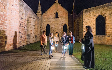 Group on a night tour at Port Arthur Historic Site, Tasmania, with a guide.