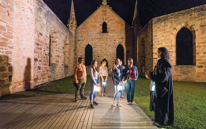 Group on a night tour at Port Arthur Historic Site, Tasmania, with a guide.