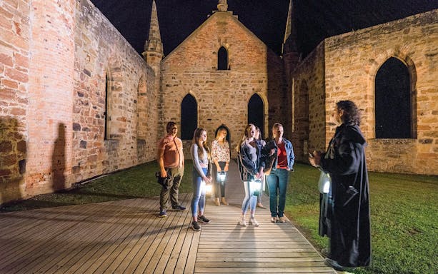 Group on a night tour at Port Arthur Historic Site, Tasmania, with a guide.