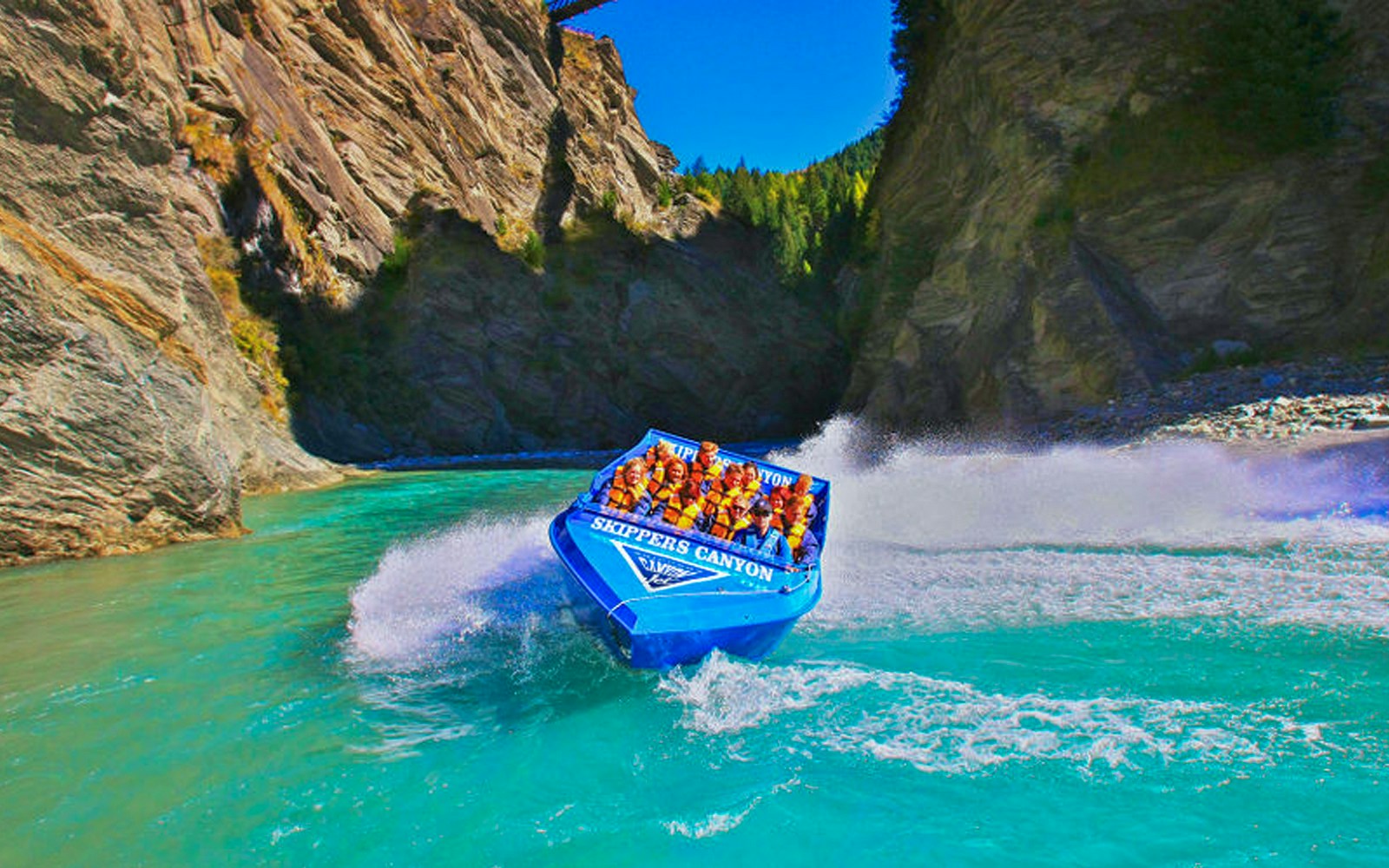 Blue jet boat speeding through Skippers Canyon, New Zealand.