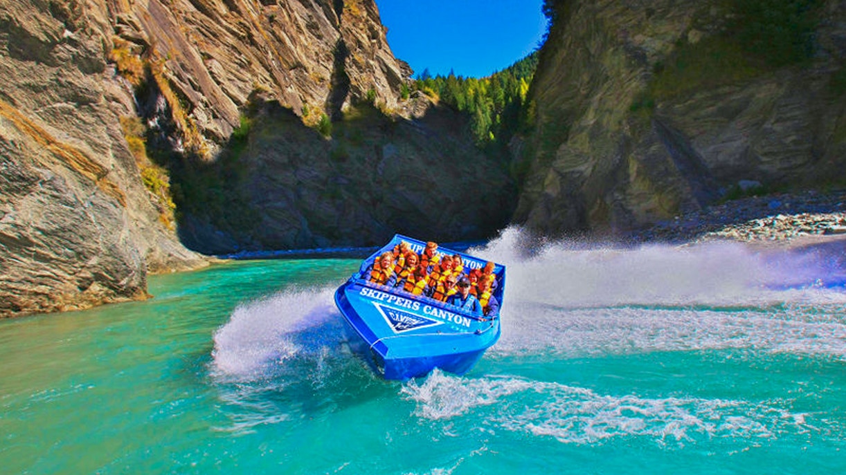 Blue jet boat speeding through Skippers Canyon, New Zealand.