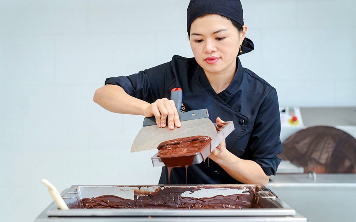 Host demonstrating chocolate making at Choco-Story Brussels Museum.