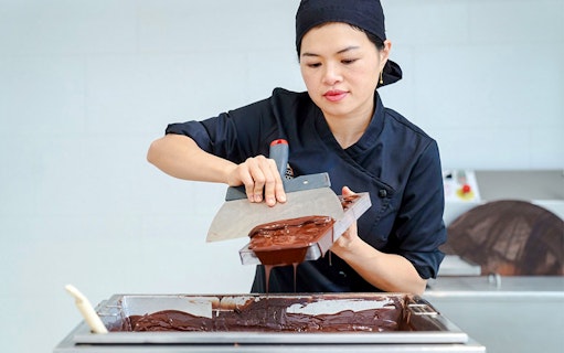 Host demonstrating chocolate making at Choco-Story Brussels Museum.