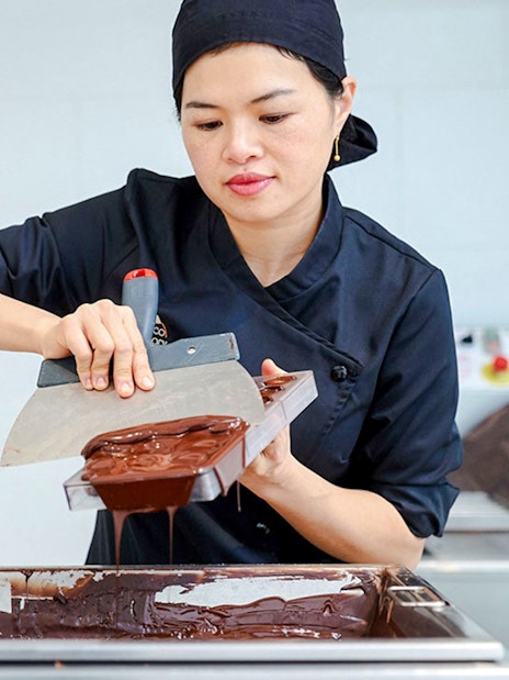 Host demonstrating chocolate making at Choco-Story Brussels Museum.