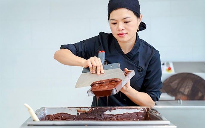 Host demonstrating chocolate making at Choco-Story Brussels Museum.