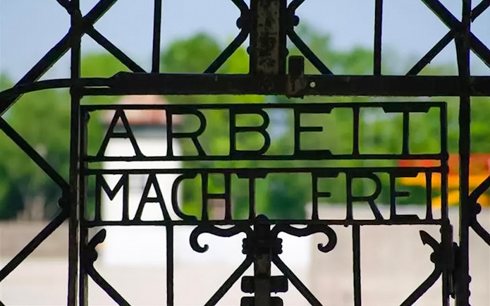 Wrought iron gate with "Arbeit Macht Frei" at Dachau Concentration Camp entrance.
