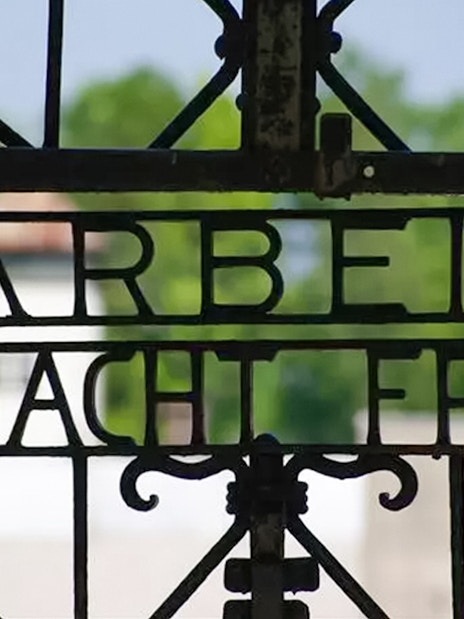 Wrought iron gate with "Arbeit Macht Frei" at Dachau Concentration Camp entrance.