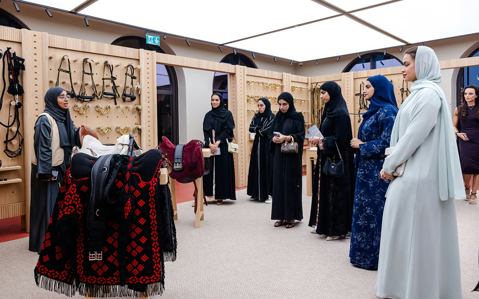 Visitors on the Abu Dhabi Royal Equestrian Arts tour observe traditional saddles and tack.