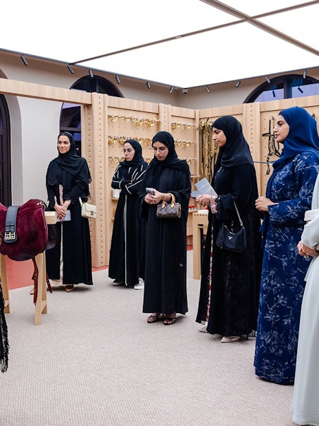 Visitors on the Abu Dhabi Royal Equestrian Arts tour observe traditional saddles and tack.