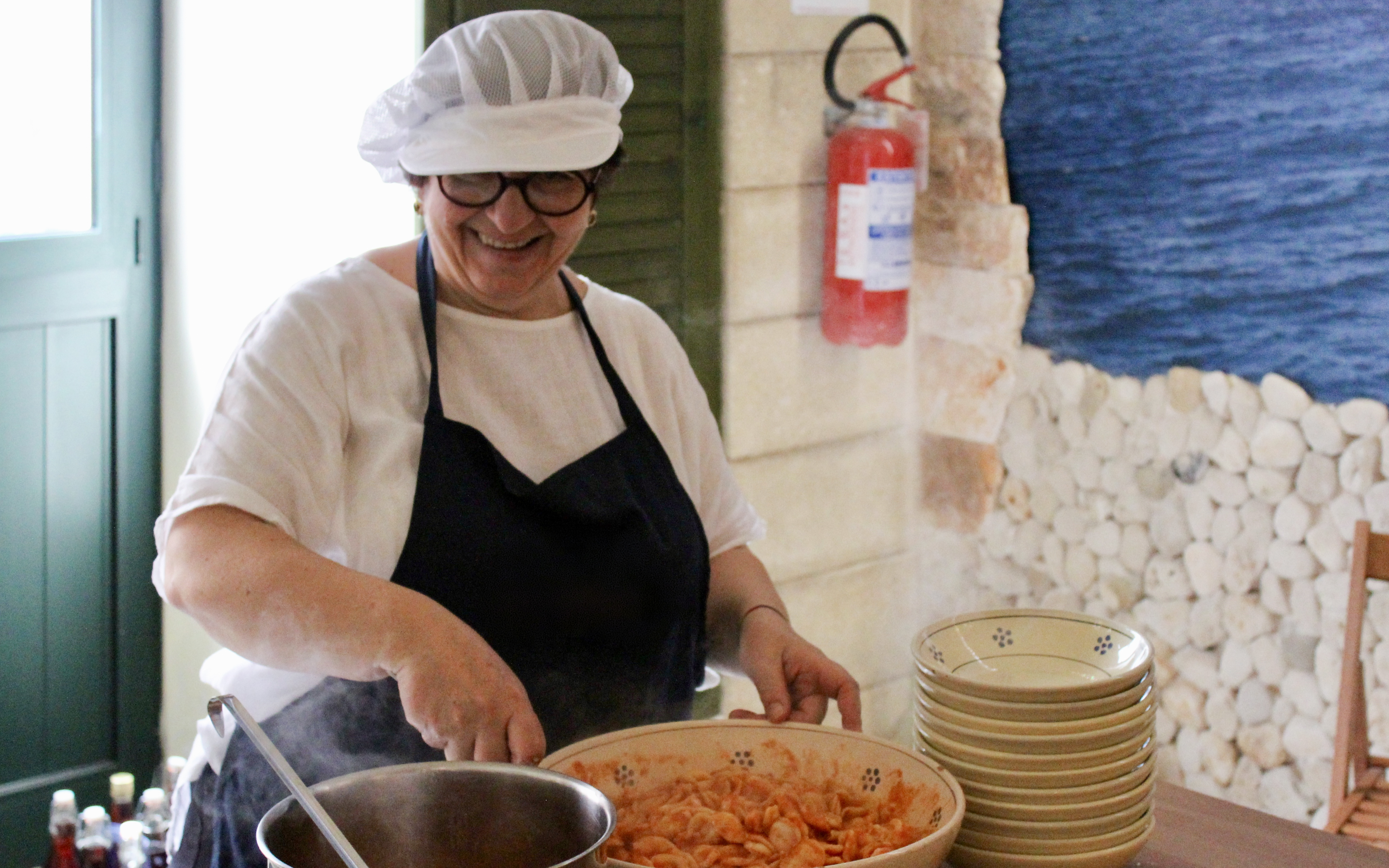 Cooking instructor preparing pasta during Polignano a Mare cooking class.