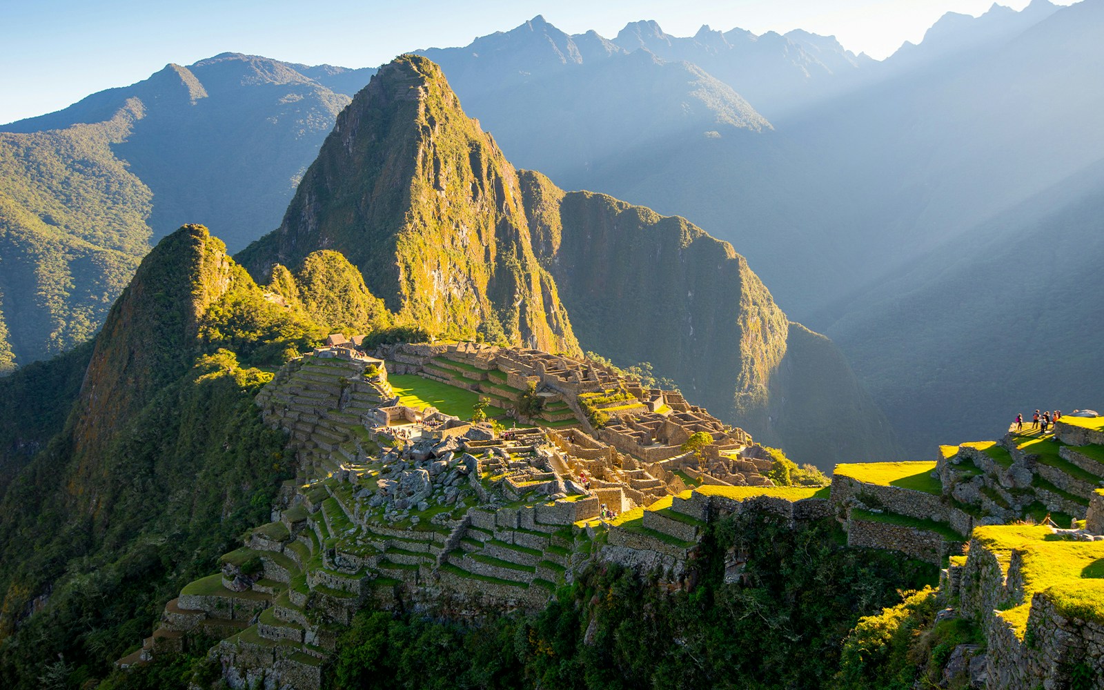 Machu Picchu, Peru, a UNESCO World Heritage Site, with ancient Incan ruins surrounded by lush green mountains under a clear blue sky