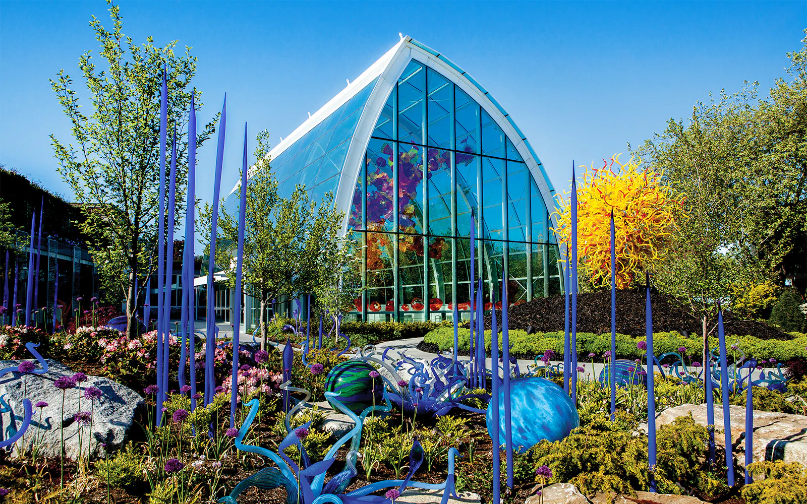 Chihuly Garden and Glass house with vibrant glass sculptures and spring blooms in Seattle.
