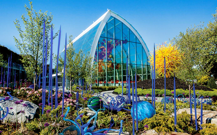 Chihuly Garden and Glass house with vibrant glass sculptures and spring blooms in Seattle.