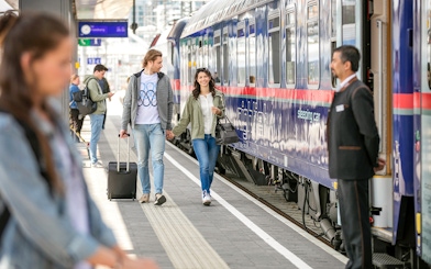 Couple boarding Eurail train at station platform.