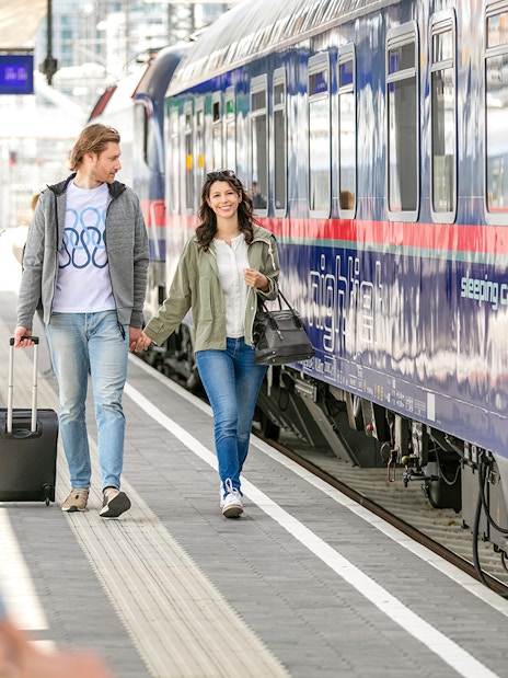 Couple boarding Eurail train at station platform.
