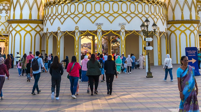 Visitors entering the ornate entrance of Global Village in Dubai.