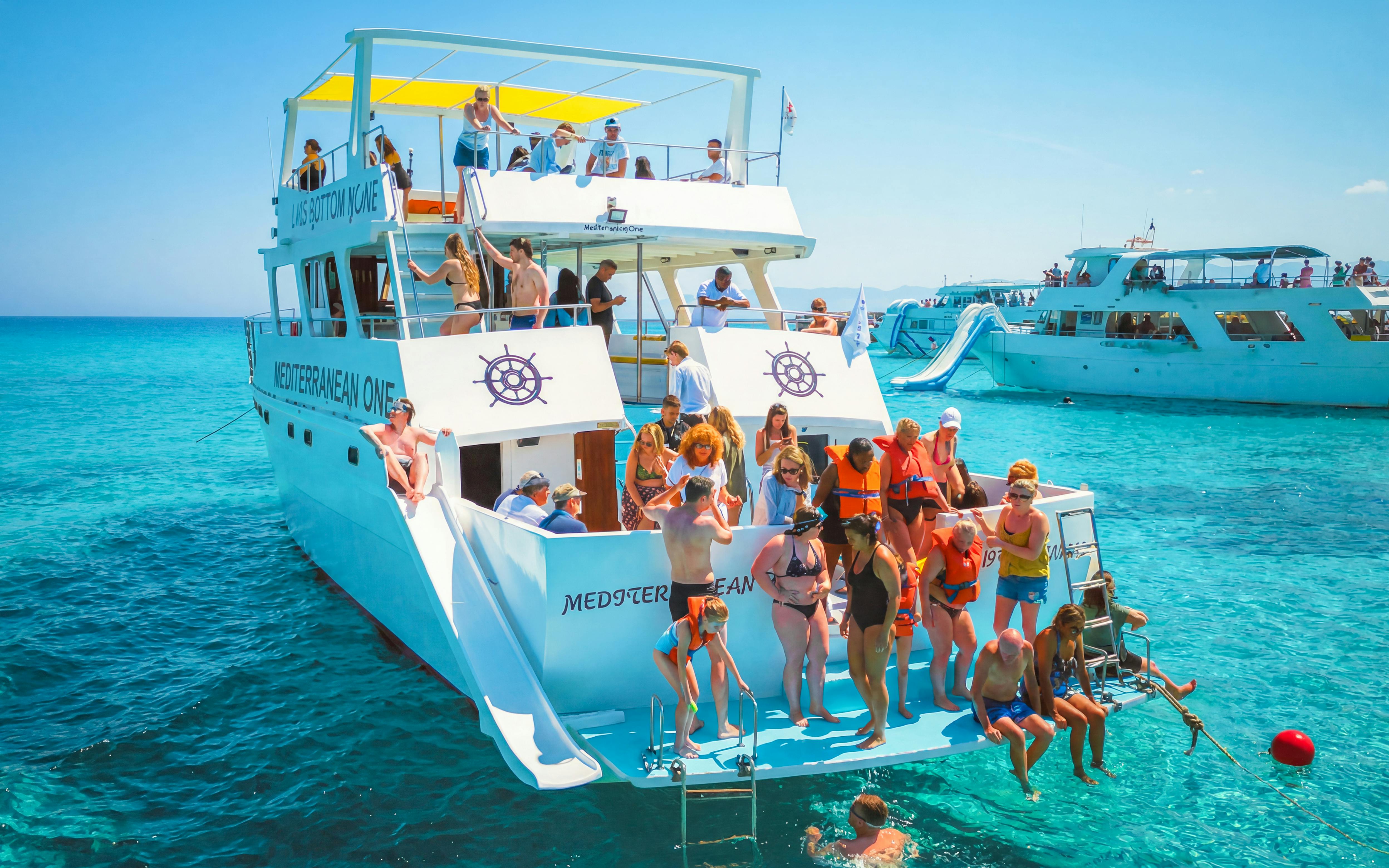 Tourists enjoying a boat trip at Blue Lagoon near Paphos, Cyprus.