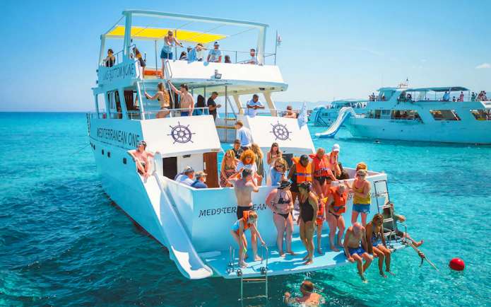 Tourists enjoying a boat trip at Blue Lagoon near Paphos, Cyprus.