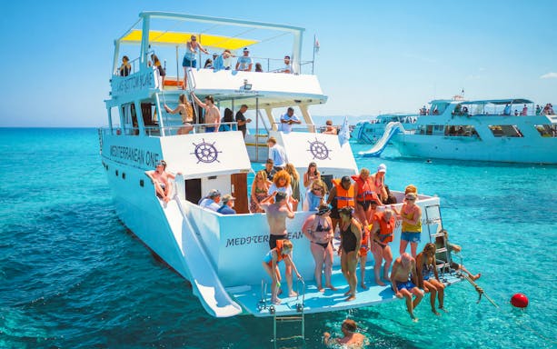 Tourists enjoying a boat trip at Blue Lagoon near Paphos, Cyprus.