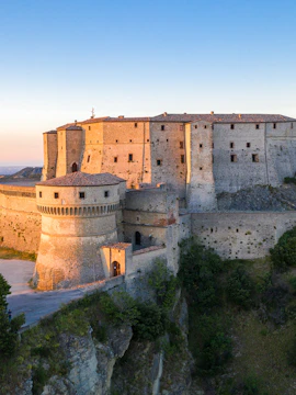 San Leo Fortress on a cliff at sunset, Italy.