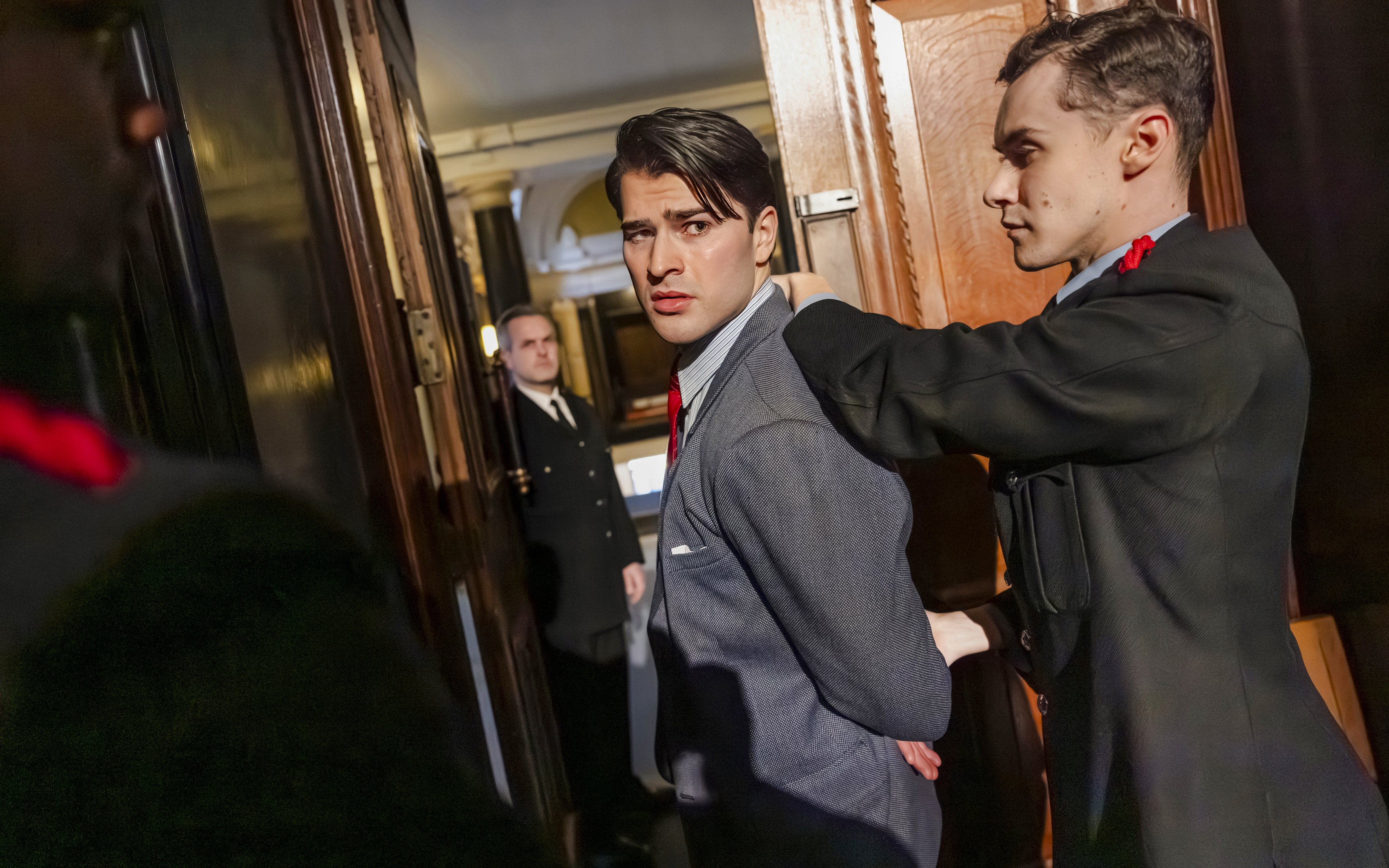 Cast members of "Witness for the Prosecution" in courtroom attire during a West End show scene.