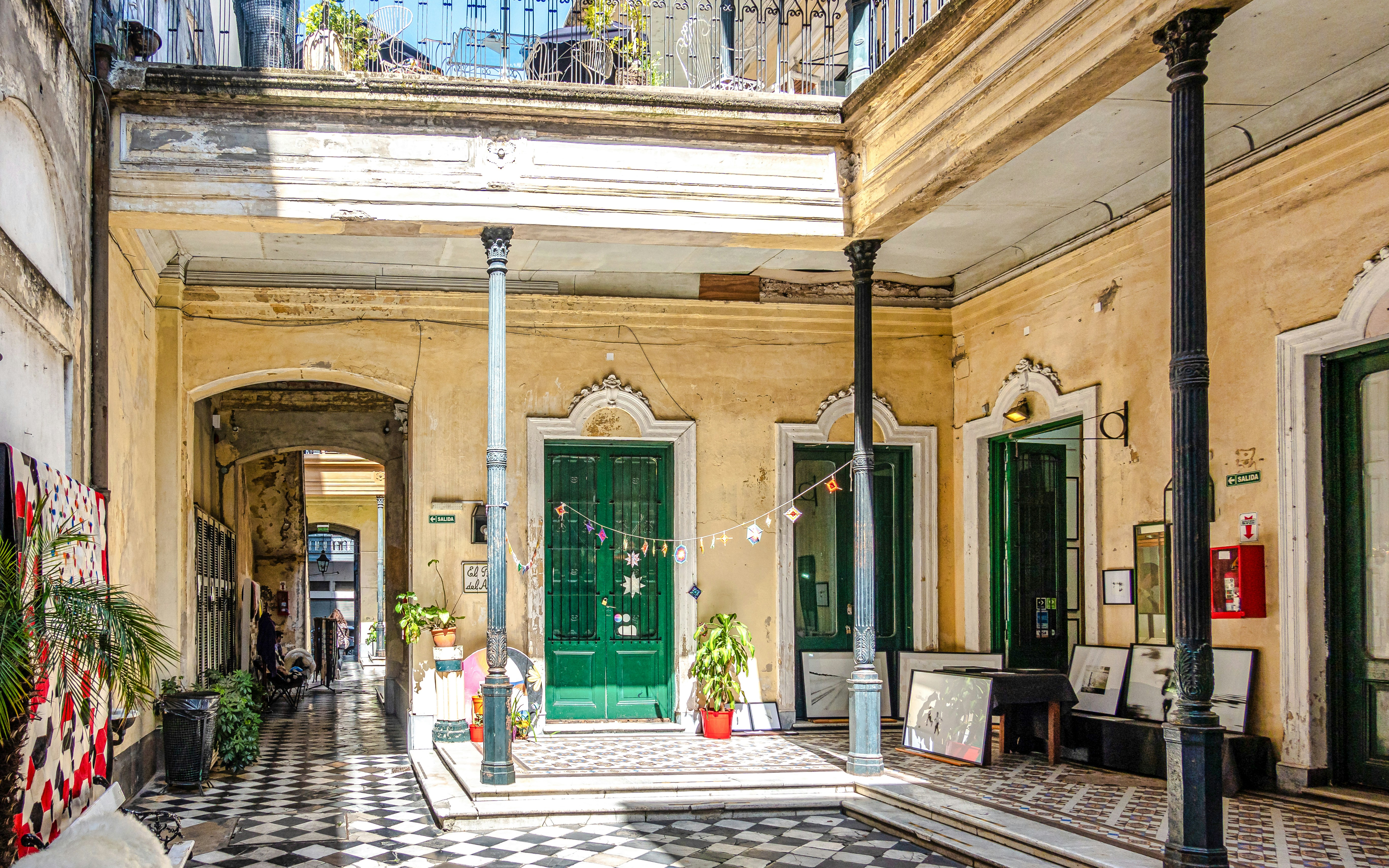 Pasaje de la Defensa courtyard with green doors and decorative tiles in San Telmo, Buenos Aires.