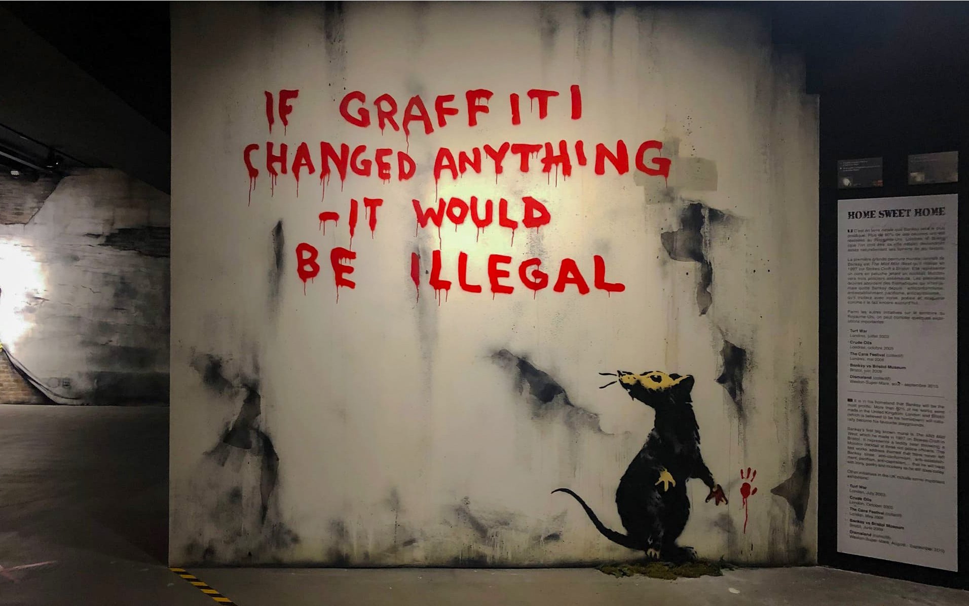Graffiti art with a rat and text at Banksy Museum, Amsterdam.
