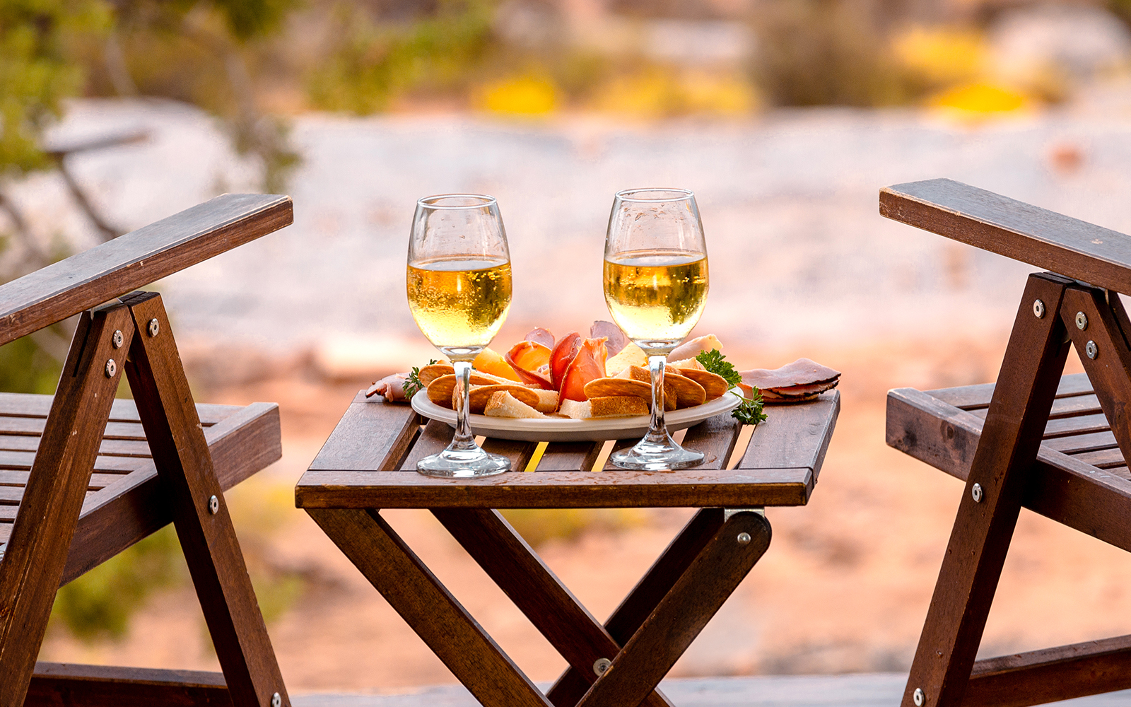 Breakfast setup with wine glasses and snacks on a wooden table in Ras Al Khaimah.