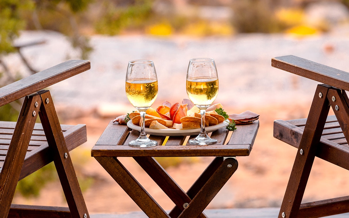 Breakfast setup with wine glasses and snacks on a wooden table in Ras Al Khaimah.