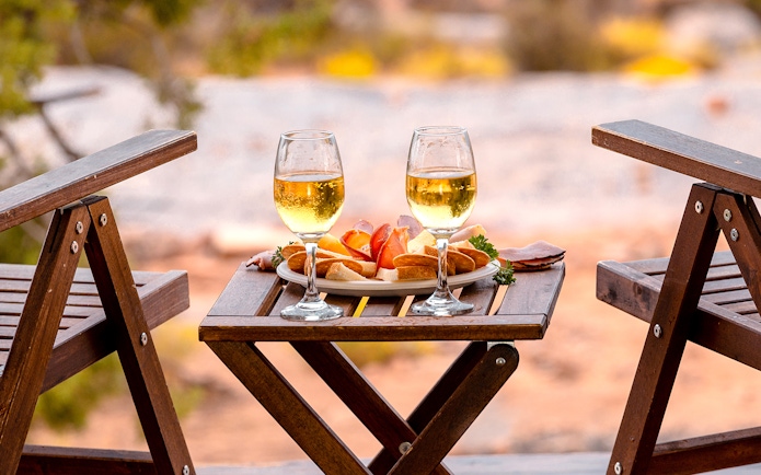 Breakfast setup with wine glasses and snacks on a wooden table in Ras Al Khaimah.