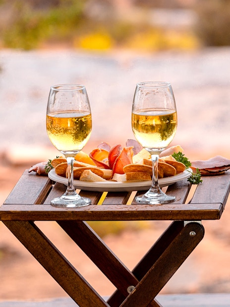 Breakfast setup with wine glasses and snacks on a wooden table in Ras Al Khaimah.