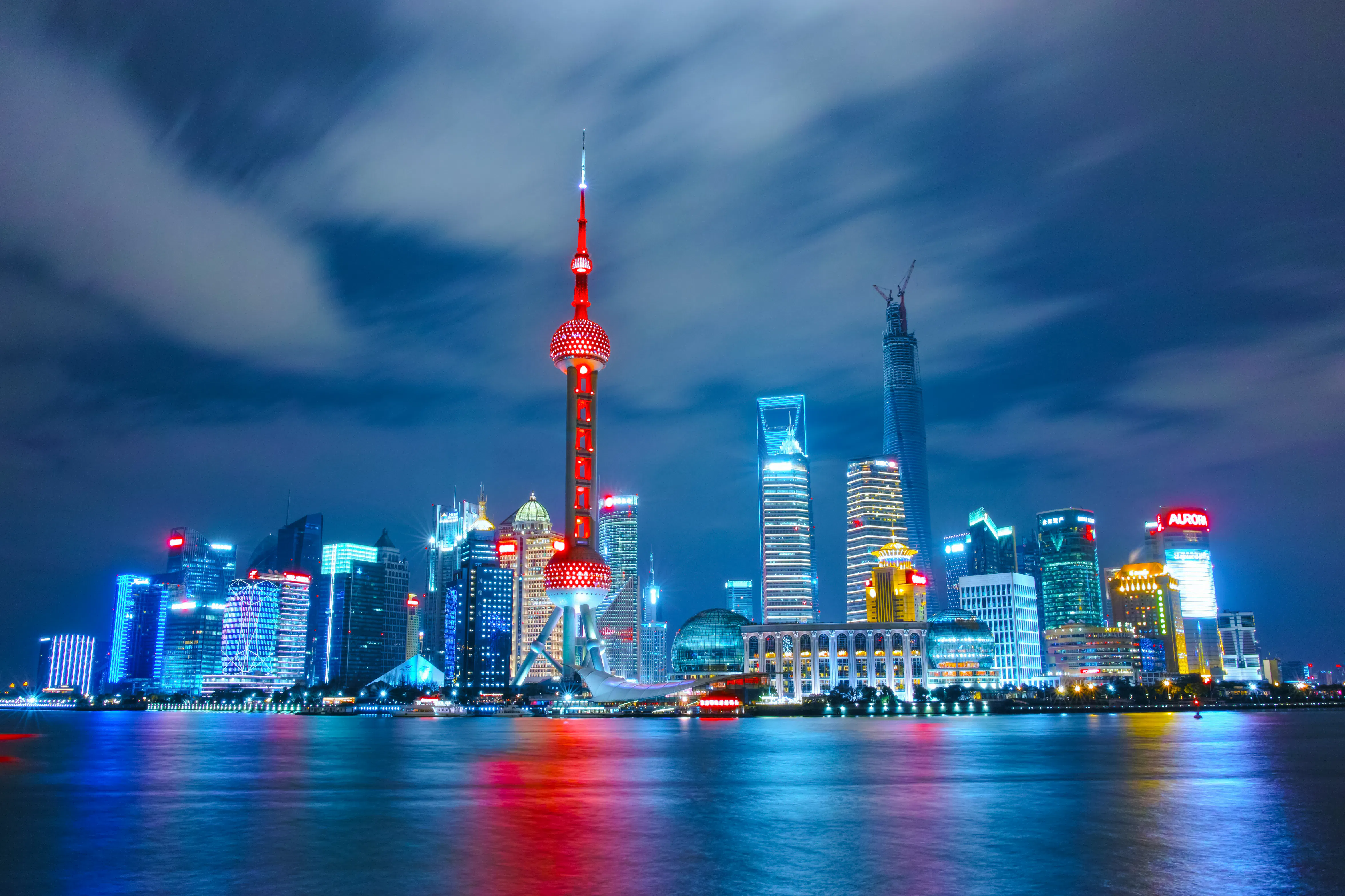 Shanghai skyline featuring the illuminated Oriental Pearl Tower at night.