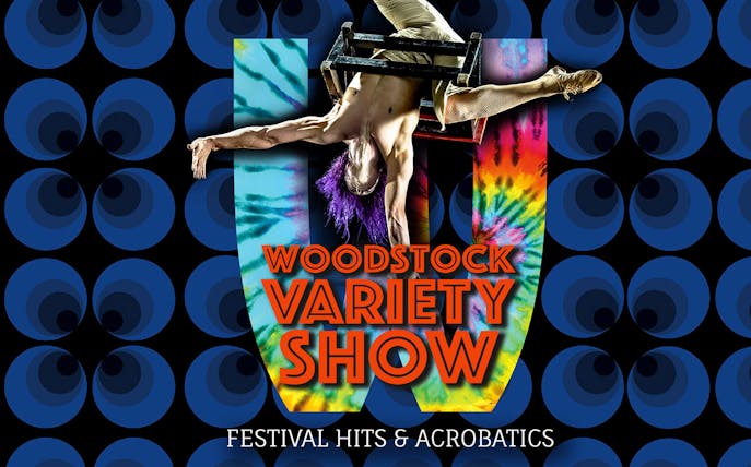Performer in acrobatic pose at Woodstock Variety Show with colorful backdrop.