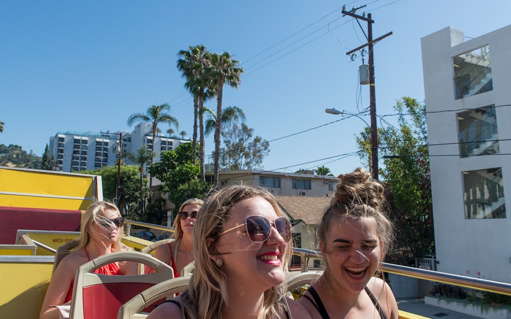 Tourists enjoying a sunny day on a Los Angeles hop-on hop-off bus tour.