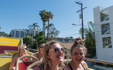 Tourists enjoying a sunny day on a Los Angeles hop-on hop-off bus tour.